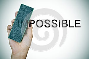 Deleting the word impossible with an eraser photo