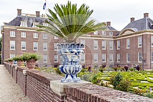 Delft blue flower pot with fern on a wall along one of the gardens of Paleis Het Loo in Apeldoorn, the Netherlands