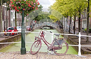 Delft city view in the Netherlands with water canal and vintage bicycle