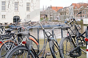 Delft, Netherlands. Bicycles parked alongside a channel on beautiful old buildings background.