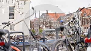 Delft, Netherlands. Bicycles parked alongside a channel on beautiful old buildings background.