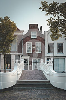 Canal house in Delft and beautiful white bridge on the Voorstraat