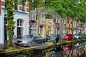 Cars on canal embankment in street of Delft. Delft, Netherlands