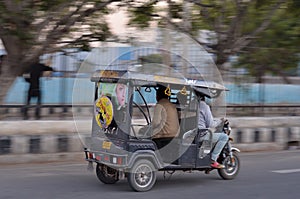 Delhi, India, 2020.Panning shot of a speeding e- rickshaw on Delhi roads. Electric rickshaws are economical mode of transportation