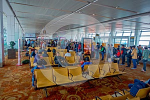 DELHI, INDIA - SEPTEMBER 19, 2017: Unidentified people sitting in a chair inside of Delhi airport waiting for the flight