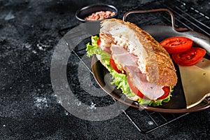 Deli meat sandwich with turkey ham, cheese, tomato and Lettuce. Black background. Top view. Copy space