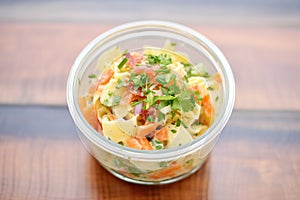 deli-style pasta salad with mayo and diced carrots, in a deli container