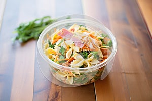 deli-style pasta salad with mayo and diced carrots, in a deli container