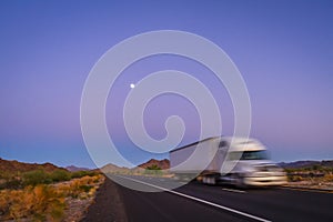 Deliberately blurred 18 wheel long haul truck on highway in desert