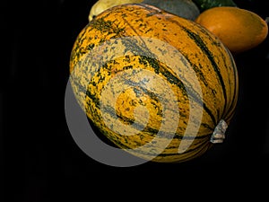 Delicata squash on a black wooden surface