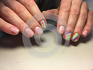 delicate beige manicure with a rainbow design on a textural background