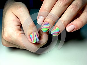 delicate beige manicure with a rainbow design on a textural background