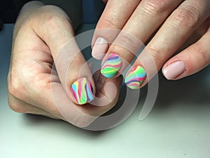 delicate beige manicure with a rainbow design on a textural background