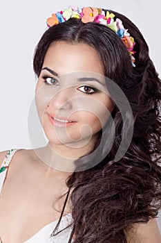 Delicate elegant beautiful schaslivo smiling woman with long black hair curls with a colored rim of the colors in a bright dress