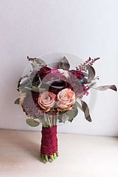 Delicate, expensive, trendy bridal wedding bouquet of flowers in marsala and red color.