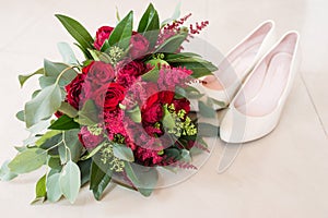 Delicate, expensive, trendy bridal wedding bouquet of flowers in marsala and red color. Wedding bouquet with red roses and greener