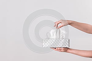 Delicate female hands holding a tissue box