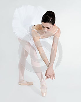 Delicate and graceful. Supple young ballerina dancing against a white background.