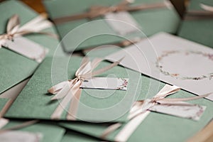 Delicate green envelopes with soft pink bows. Wedding invitation cards. Autumn Wedding Invitation