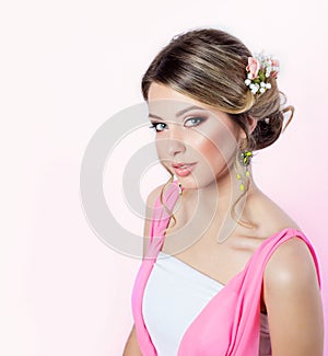 Delicate image of a beautiful woman girl like a bride with bright makeup hairstyle with flowers roses in the head in a pink dress