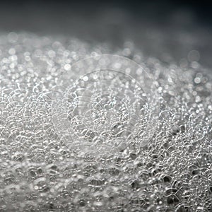 Delicate, intricate pattern of soap bubbles creates a shimmering surface. The bubbles