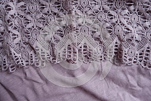 Delicate lace on puce viscose fabric photo
