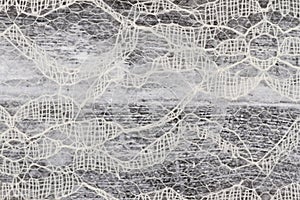 Delicate lace textured material on distressed wood background