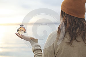 Delicate moment between a butterfly and a woman