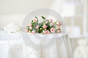 Delicate pink roses and pearl beads on the table