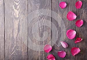 Delicate rose petals on a rough wooden board. Place for inscription