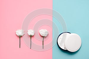 Delicate skin care cosmetic feminine flatlay. Top view Creative composition of face cream and flowers leaves on abstract