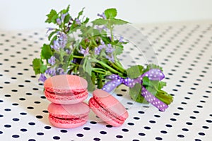 Delicate strawberry french macarons and a bouquet of wildflowers