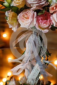 Delicate and very beautiful wedding bouquet of roses, greenery, eustoma standing on mirror table. Bridal trendy flowers