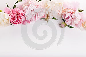 Delicate white pink peony with petals flowers and white ribbon on white. Overhead top view, flat lay. Copy space. Birthday, Mother