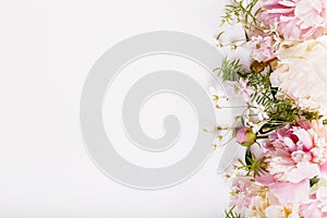 Delicate white pink peony with petals flowers and white ribbon on wooden board. Overhead top view, flat lay. Copy space