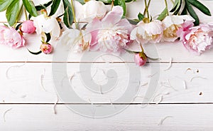 Delicate white pink peony with petals flowers and white ribbon on wooden board. Overhead top view, flat lay. Copy space. Birthday,