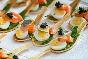 Delicates, appetizer filling with red fish, quail egg, black caviar and lime. Catering service.