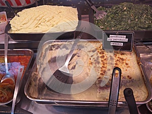 Delicatessen sold at Street market in Paris. People walking and buying food