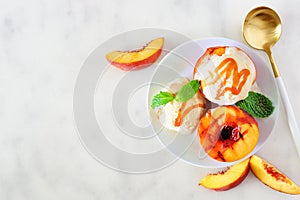 Delicios grilled peaches with vanilla ice cream, top view table scene on a white marble background photo