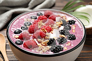 Delicious acai smoothie with berries and oatmeal on table, closeup