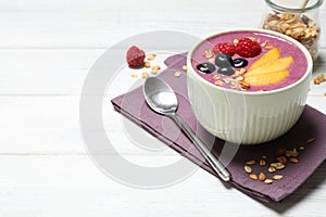 Delicious acai smoothie with fruits served on white wooden table. Space for text