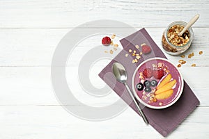 Delicious acai smoothie served on white wooden table, flat lay. Space for text