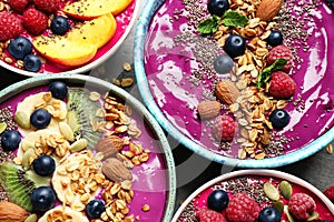 Delicious acai smoothie with toppings in bowls on table