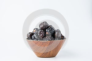 Delicious ajwa dates ( kurma nabi ) or Prophet\'s Dates, sweet dried dates in a wooden bowl