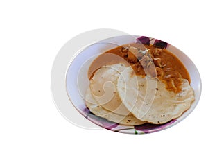 Delicious Appam/Rice rotti with chicken curry in a plate on white background