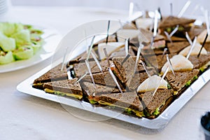 Delicious appetizer canapes of black bread on skewers