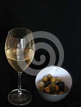 Delicious appetizer of seasoned pickled olives and wine photo