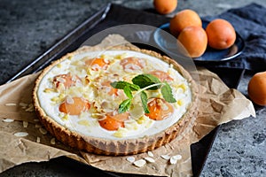 Apricot and cream cheese tart topped with almond flakes and crumble