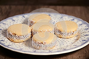 Delicious Argentinian cookies cornflow alfajores with cream dulce de leche close-up . White vanilla macaroons on white