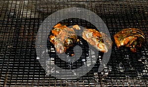 Delicious Asian fish fry served on a BBQ table. Grilled fish laid on steel grates